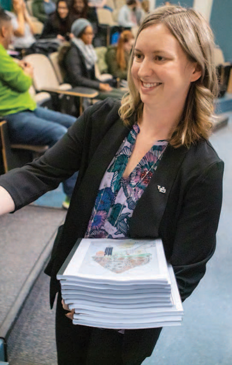 Jessica S. Kruger, PhD, passing out materials during a presentation.